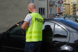 Na zdjęciu policjant podczas przeszukania samochodu, w którym znaleziono narkotyki
