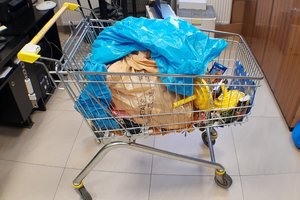 Wózek zakupowy, alkohol, tytoń i inne przedmioty odzyskane przez policjantów z włamania do sklepu.