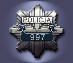 Zdjęcie przedstawiające odznakę policyjną z napisem Policja oraz numerem alarmowym 997