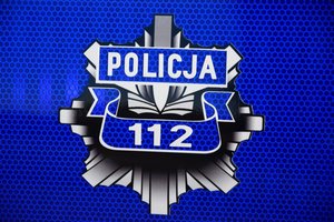 Policyjna odznaka, na której jest napis policja i numer alarmowy 112