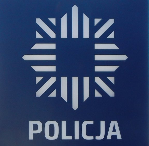 Białe logo o oraz napis policja na niebieskim tle.