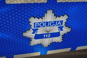 policyjne logo z numerem alarmowym 112 na drzwiach radiowozu
