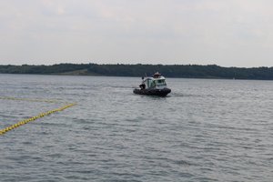 Zdjęcie przedstawia policjantów pełniących służbę na jeziorze tarnobrzeskim. Przy pomocy policyjnej łodzi prowadzono kontrole legalności połowu ryb.