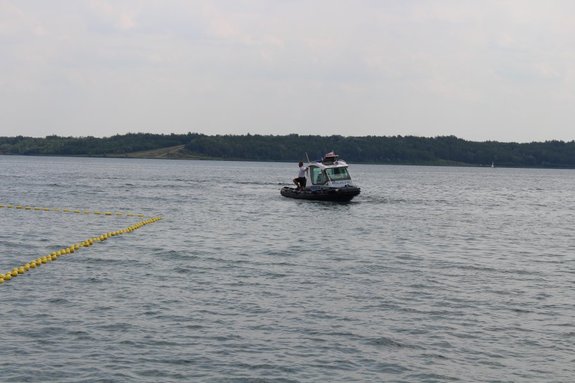 Zdjęcie przedstawia policjantów pełniących służbę na jeziorze tarnobrzeskim. Przy pomocy policyjnej łodzi prowadzono kontrole legalności połowu ryb.