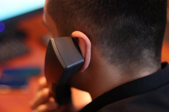 mężczyzna odwrócony tyłem ze słuchawką telefonu przy uchu