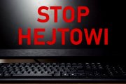 Logo kampanii &quot;STOP HEJTOWI&quot; 
Czerwony napis na tle otwartego ekrany komputera osobistego - laptopa ustawionego w ciemnej scenerii.