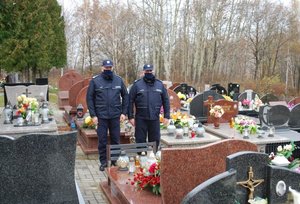 policjanci na cmentarzu, odwiedzający groby zmarłych
