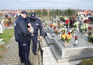 policjanci na cmentarzu, odwiedzający groby zmarłych