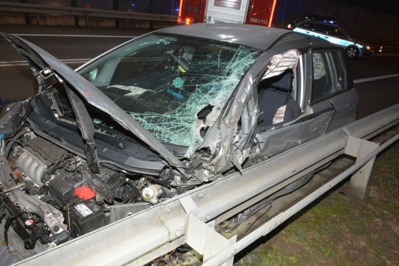 Uszkodzony pojazd który brał udział w zdarzeniu drogowym. W tle radiowóz i straż pożarna.