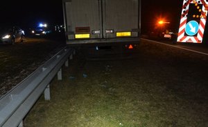 Autostrada A 4 . Na zdjęciu wykonanym nocną porą widoczna jest tylna część samochodu ciężarowego. Po prawej stronie oznaczenie drogowe, po lewej w tle znajduje się radiowóz.