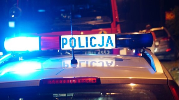 Zdjęcie przedstawia belkę radiowozu policyjnego gdzie widoczne są puszczane sygnały świetlne (światła czerwone i niebieskie)