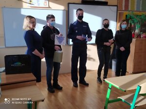 Na zdjęciu policjant (w środku) wraz z trojgiem laureatów konkursu i nauczycielką.