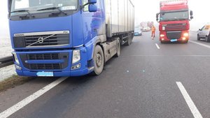 Zdjęcie przedstawia drogę krajową  77 na pierwszym planie ciężarówka z naczepa w kolorze niebieskim za pojazdem widać trzy pojazdy osobowe z tego dwa rozbite oraz wóz strażacki. Po prawej stronie widać ciężarówkę w kolorze czerwonym