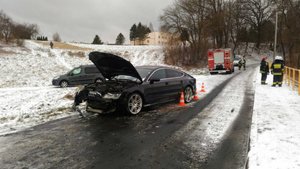 2.	Zdjęci przedstawia drogę w miejscowości Korytniki , droga zaśnieżona. Z lewej strony widoczny jest samochód marki audi koloru granatowego z rozbitą maską silnika, za nim zaparkowany pojazd straży pożarnej oraz dwóch strażakow. Po lewej stronie widoczna poręcz mostka i dwóch strażaków.