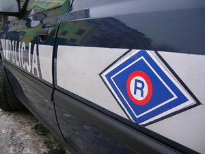 Logo ruchu drogowego Na radiowozie widoczna litera  R, umieszczona w rąbie na granatowym tle.
