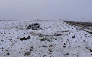 Miejsce zdarzenia drogowego oraz uszkodzony pojazd znajdujący się na polu ornym