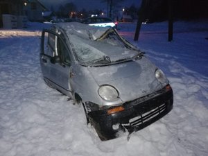 Samochód wydobyty z rzeki, stojący na śniegu. Widoczne uszkodzenia pojazdu. Widok od przodu.