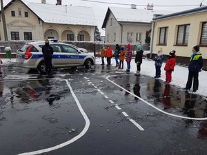 policjantka podczas spotkania przed budynkiem szkoły SP nr 13 w Mielcu wraz z dziećmi i nauczycielkami, na fotografii widnieje również radiowóz