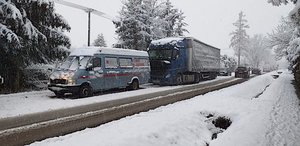 Zderzenie w Dobrzechowie w powiacie strzyżowskim. Bus osobowy koloru błękitnego, za nim niebieska ciężarówka z białą naczepą. W tle zimowa sceneria - zaśnieżona droga i drzewa.