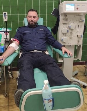 policjant w umundurowaniu oddaje krew na sali szpitalnej