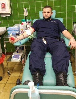 policjant w umundurowaniu oddaje krew na sali szpitalnej