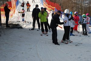 5  Zdjęcie kolorowe przedstawia stok narciarski w Przemyślu w tle widoczni narciarze oraz policjantka zakładajaca odblask na rękę mężczyzny