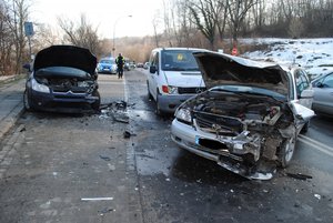 zdjęcie przedstawia drogę ul. Sanocką w Przemyślu na której doszło do zdarzenia drogowego. Przedstawione na zdjęciu są trzy rozbite pojazdy srebrna toyota,mercedes Vito w kolorze białym oraz granatowy Citroen.W oddali zdjęcia widoczny policjant ruchu drogowego w kamizelce odblaskowej i białą czapka na głowie a w oddali widoczny radiowóz oznakowany.