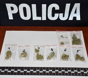 Zatrzymane narkotyki - marihuana w woreczkach foliowych. W tle napis Policja.