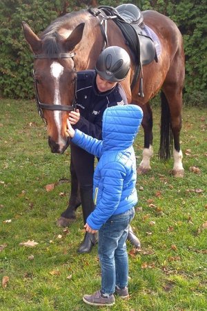 Policjantka z wydziału konnego podczas spotkania z dzieckiem.