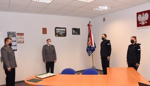 Na zdjęciu w pomieszczeniu biurowym stoi czterech umundurowanych policjantów.