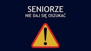 Zdjęcie wyświetlone jest na czarnym tle-przedstawia znak  drogowy ostrzegawczy tj, trójkąt koloru żółtego z czerwoną otoczką. W środku umieszczony jest wykrzyknik w kolorze czarnym . Nad znakiem na czarnym tle umieszczony jest napis  SENIORZE-NIE DAJ SIĘ OSZUKAĆ napisany białymi dużymi literami.