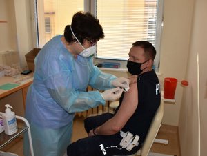 Pielęgniarka aplikuje szczepionkę policjantowi
