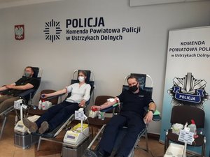trzy osoby oddają krew, od prawej strony Komendant Powiatowy Policji w Lesku podinsp. Grzegorz Koczera