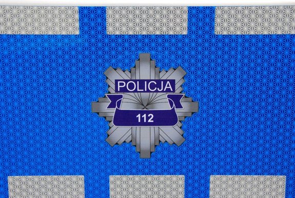 Drzwi policyjnego radiowozu, na których widoczna jest policyjna gwiazda i napis 112