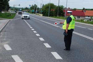 Policjant ruchu drogowego zatrzymujący pojazd do kontroli