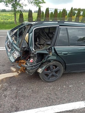 Zdjęcie kolorowe przedstawia miejsce zdarzenia drogowego miejscowość Żurawica . Na zdjęciu widoczny jest uszkodzony pojazd marki bmw koloru zielonego. W tle widoczne są tereny zielone oraz budynek .