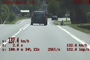 Zdjęcie z policyjnego wideorejestratora. Samochód jadący prostym odcinkiem drogi widziany od tyłu. W lewym dolnym rogu widoczny pomiar prędkości - wyświetlany czerwoną czcionką. Pomiar zatrzymuje się na wskazaniu 137,4 km/h.