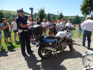 Policjant prezentujący wyposażenie motocykla służbowego.