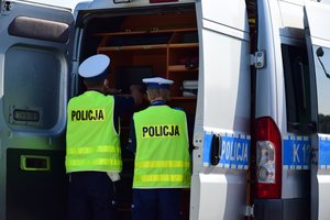 policjanci stojący przy radiowozie