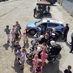 Dzieci zgromadzone na placu oglądają motocykle i radiowóz