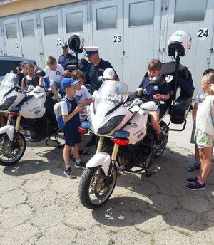 Dzieci na policyjnych motocyklach. Obok nich funkcjonariusze