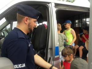 na zdjęciu policjant pokazuje dzieciom radiowóz
