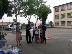 na fotografii Zastępca Komendanta Powiatowego Policji w Mielcu wraz z wójtem i panią dyrektor szkoły wręczają dzieciom nagrody