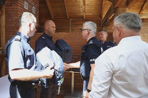 Komendant Wojewódzki Policji w Rzeszowie wręcza dwóm policjantom torby ratownicze