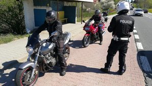 w zatoczce autobusowej dwaj motocykliści, przed nimi policjant. W tle jadące samochody