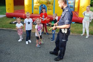 Policjant rozdający elementy odblaskowe dzieciom