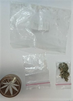Zabezpieczone trzy woreczki strunowe z marihuaną ,  białą skrystalizowaną substancją oraz młynek do mielenia.