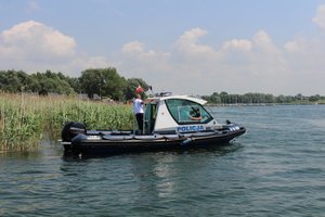 Na akwenie wodnym - Jeziorze Tarnobrzeskim policyjni wodniacy pływając łodzią czuwają nad bezpieczeństwem wypoczywających osób.