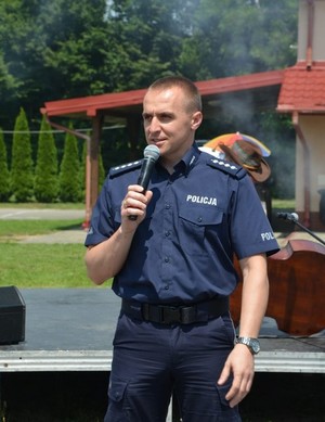 policjant z mikrofonem podczas prelekcji dla seniorów w Miejscu Piastowym