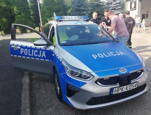 policyjny radiowóz, do którego wsiadają dzieci podczas pikniku w Polance